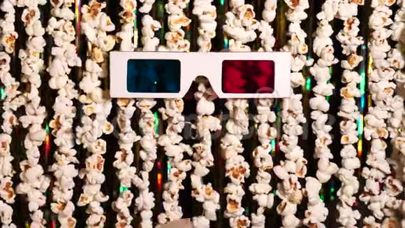 猫爪子玩3D眼镜爆米花和金色闪闪发光的金属圈的动态背景离焦视频的预览图