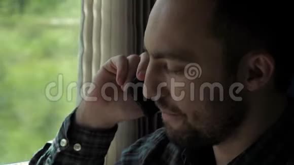 男人打完电话看着火车的窗户视频的预览图