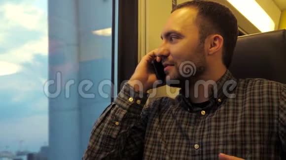坐地铁列车的白种人年轻人用手机说话视频的预览图