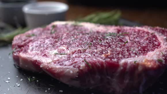 牛肉牛排撒上大海盐一块多汁的新鲜大理石牛肉撒上香料视频的预览图