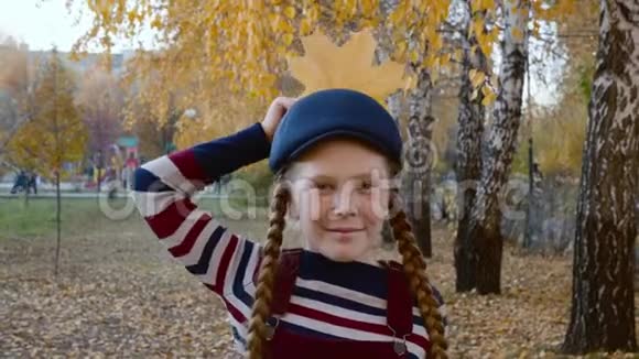 穿着条纹衣服的少女和蓝帽头附近有黄色的枫叶像乌鸦一个快乐的女孩视频的预览图