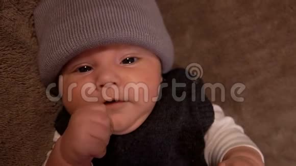 戴着灰色帽子的可爱的小黑眼婴儿视频的预览图