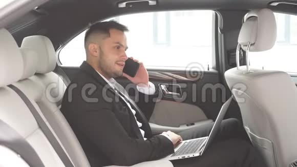 优雅的年轻人留着胡子打电话在车里工作视频的预览图
