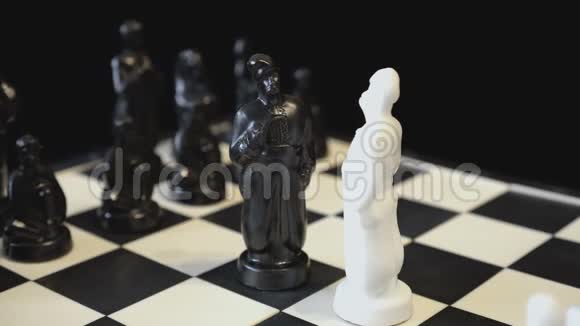 两个棋王黑白两色面对面的对着一个旋转的黑白棋盘以国际象棋的形式视频的预览图