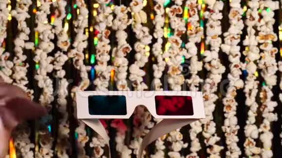猫爪子玩3D眼镜爆米花和金色闪闪发光的金属圈的动态背景离焦视频的预览图