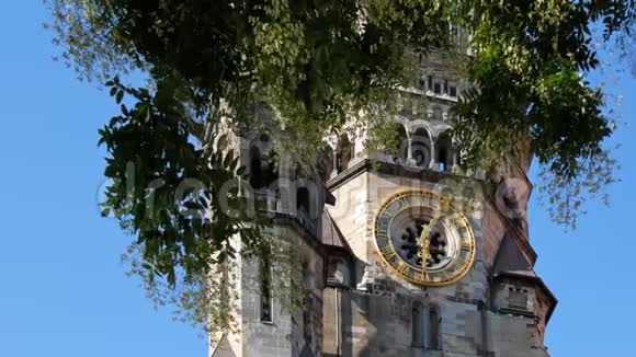 德国柏林一棵树后凯撒威廉纪念教堂的钟视频的预览图