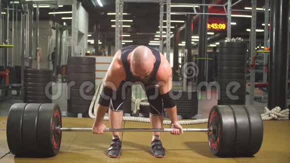 强壮的健美运动员手里拿着重金属杠铃做举重运动视频的预览图