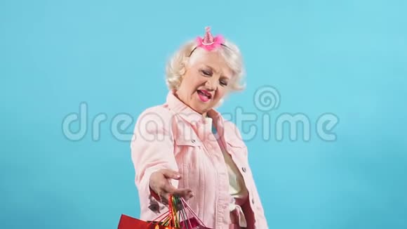 微笑积极的奶奶购物袋显示拇指视频的预览图