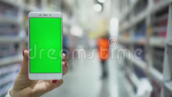 Pov女性手提智能手机带着空白绿色屏幕在购物中心散步视频的预览图