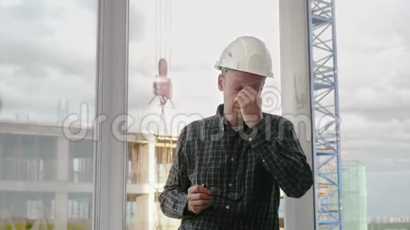 这位戴白色安全帽的工人因工作而累工作背景是建筑工地视频的预览图