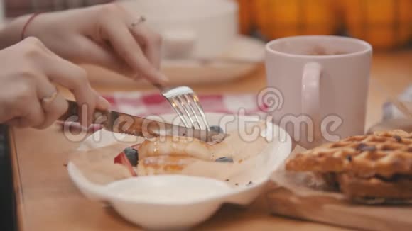 女人正在切一片芝士蛋糕上面有浆果和糖浆视频的预览图