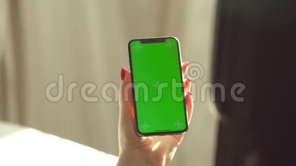 商务女性使用智能手机观看绿屏手机浏览色度键在线观看享受视频的预览图