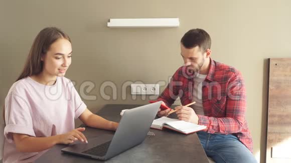 英俊的男人和漂亮的年轻女人一起在笔记本电脑前度过时光视频的预览图