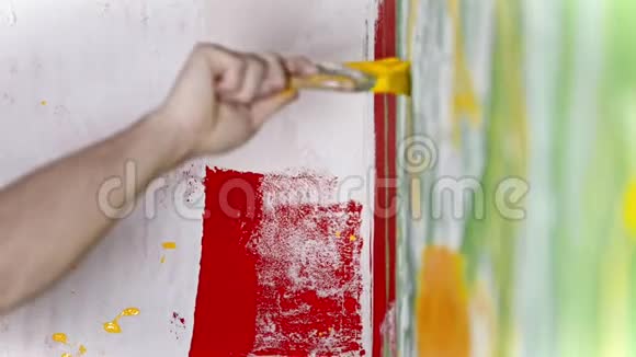 手在白色和绿色的墙上用黄色油漆写东西视频的预览图