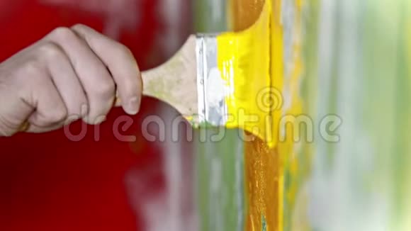 把涂满黄色油漆的刷子推到墙上视频的预览图