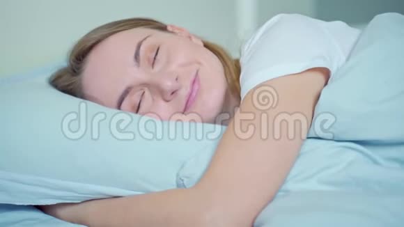 女人睡得很好抱着柔软的白色枕头少女休息晚安的概念视频的预览图