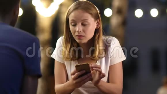 可爱的女孩在她男朋友和她说话的时候用电话视频的预览图