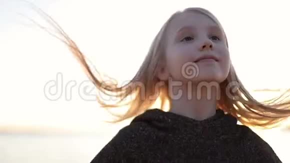 美丽的日落背景上可爱的金发女孩的特写脸视频的预览图
