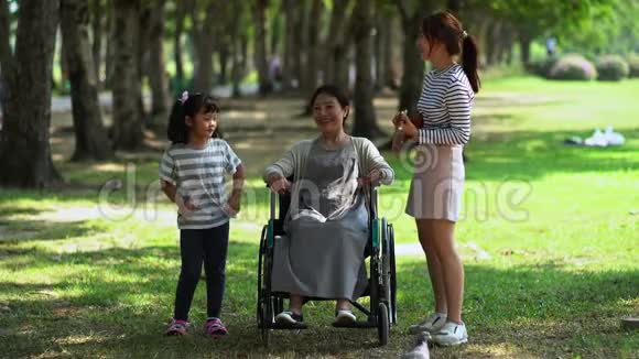 快乐的母亲和两个可爱的女儿在公园里视频的预览图