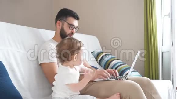 戴眼镜的长胡子聪明英俊的男人在笔记本电脑上工作视频的预览图