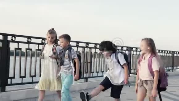 快乐的四个年轻学生放学后散步和交谈视频的预览图