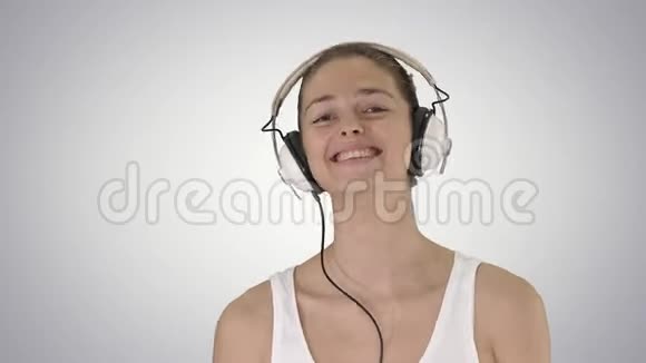 音乐人与科技理念幸福微笑的女人带着耳机走在梯度背景上视频的预览图