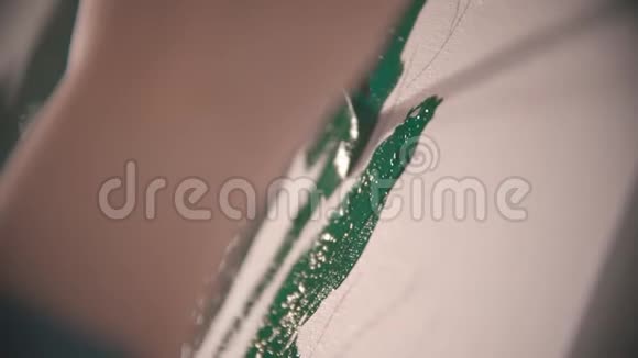 一个年轻的女人她的手在画布上画一顶绿树冠视频的预览图