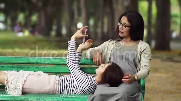 十几岁的女儿睡在公园里的大腿母亲视频的预览图