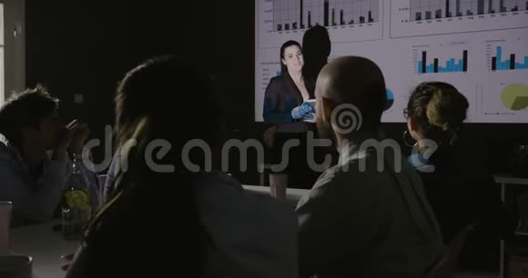 年轻的商业女性团队负责人在投影仪上展示项目策略视频的预览图