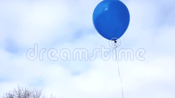 一个蓝色气球在一根绳子上在风中在蓝天和云彩上飞行4K视频视频的预览图