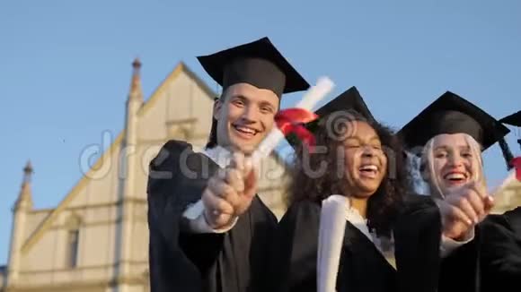 毕业典礼五个朋友捧出文凭微笑面对镜头视频的预览图