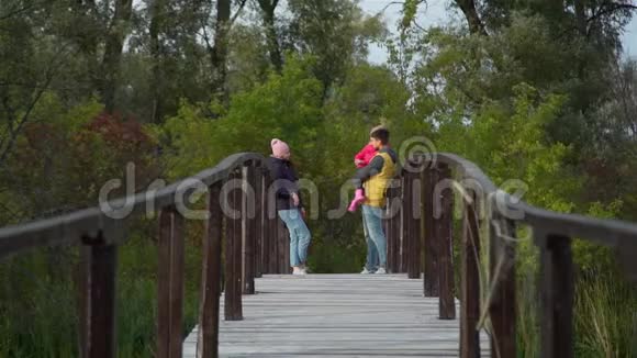 一家人站在秋日的木桥上视频的预览图