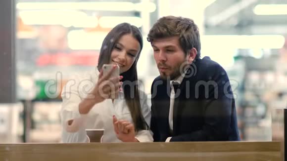 一对穿着正装的年轻夫妇用手机自拍视频的预览图