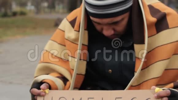 冻僵的男人被毯子覆盖要求在街上施舍无家可归视频的预览图
