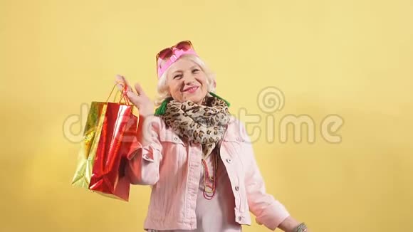 快乐快乐迷人的老年女性带着被隔离在黄色的购物袋视频的预览图