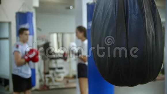 一男一女正在进行拳击训练前台挂着拳击袋视频的预览图
