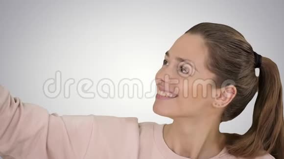 微笑开朗金发女人做自拍梯度背景视频的预览图