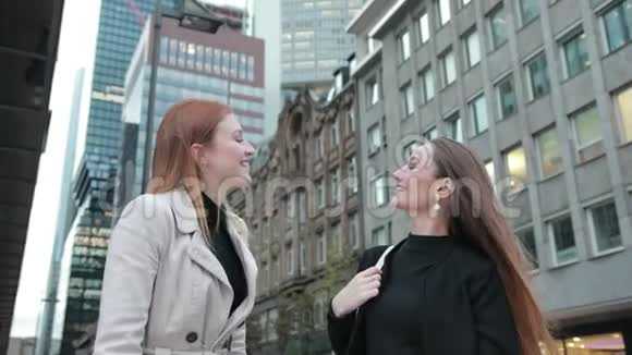 两位年轻迷人的女士穿着时尚休闲服装在市中心交谈视频的预览图