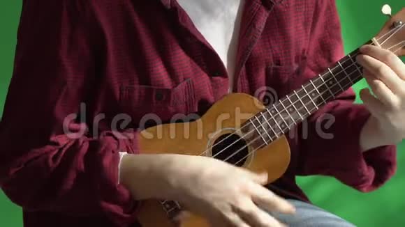 在一个绿色的背景下年轻的希普斯特女人演奏尤库莱吉他视频的预览图