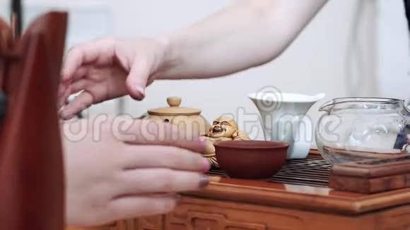 中国的茶道仪式上女孩们用手从木桌上拿着小茶杯视频的预览图
