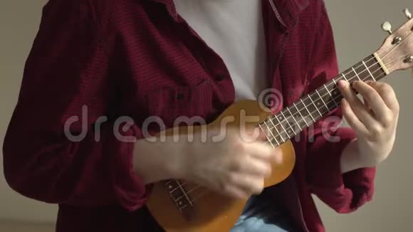 年轻的希普斯特女人演奏尤库莱吉他4K视频的预览图