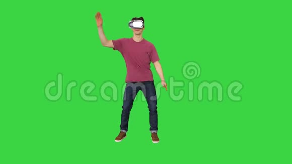 休闲男子在VR眼镜跳舞玩电子游戏初学者水平的绿色屏幕铬键视频的预览图