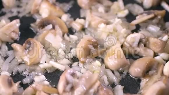 锅中炒洋葱和香葱蘑菇慢动作烹饪视频的预览图