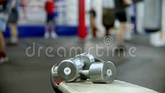 一个拳击手训练健身房两个6公斤的哑铃在前台视频的预览图