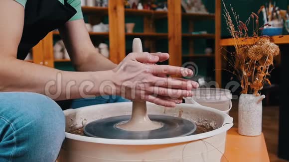 陶器工艺一个人在陶工车轮上形成一块较长形状的粘土视频的预览图