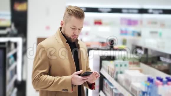 小胡子男在购物中心用手机上网聊天视频的预览图