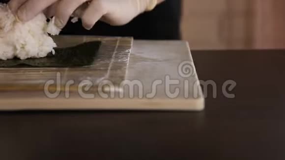 寿司师傅的特写在诺里铺饭寿司制作工艺厨师的手竹垫视频的预览图