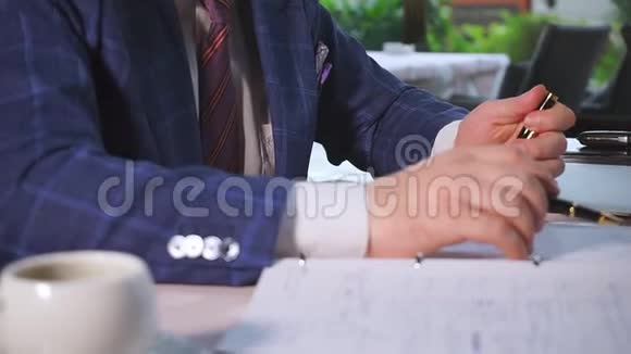 穿蓝色夹克和领带的男人拿着昂贵的黑色钢笔视频的预览图