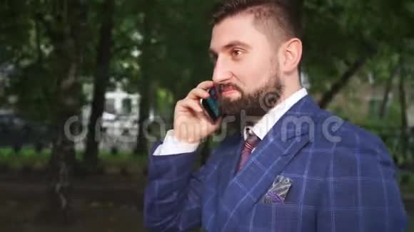 有着棕色浓密胡须的帅哥在智能手机上讲话视频的预览图