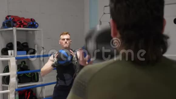 运动员训练在搏击俱乐部拳击场上投掷药球拳击手在热身时互相投掷球视频的预览图